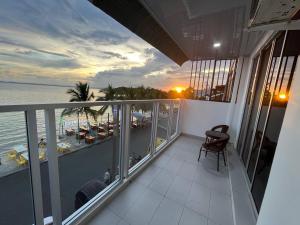 a balcony with a view of the ocean at sunset at Homestay Tawau With Seaview. Anekayangan Homestay in Tawau