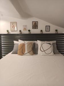 a large white bed with four pillows on it at bijou loft in La Spezia