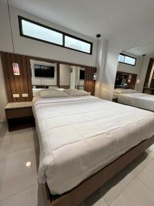 una camera da letto con un grande letto bianco e una finestra di NOVAPARK HOTEL a Guayaquil
