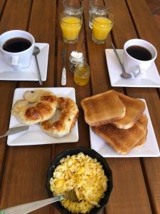 una mesa de madera con platos de comida y tazas de café en Petit Deluxe Salta en Salta
