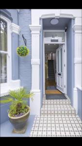 a blue house with a porch with a potted plant at Alexander House in London