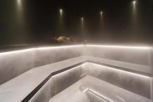 - une baignoire dans une pièce éclairée dans l'établissement Les Gentianettes Hotel & Spa, à La Chapelle-dʼAbondance