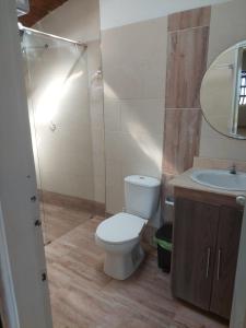 ein Badezimmer mit einem WC, einem Waschbecken und einem Spiegel in der Unterkunft Finca Villa Gloria Copacabana in Copacabana