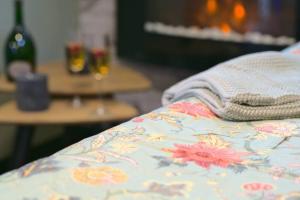 eine Decke mit Blumen auf dem Bett in der Unterkunft Littleparadise jacuzzi à 5 minutes du centre ville in Mulhouse