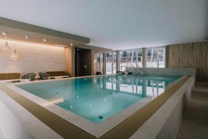 a large swimming pool in a building at TheChipp - Designapartment mit Seeblick, Pool, Sauna & Kamin in Bad Saarow