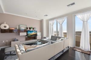 a living room with a couch and a tv at Luxury Living at The Grand in Wildwood