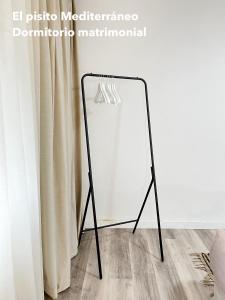 a mirror on a tripod next to a curtain at El pisito mediterráneo in Melilla
