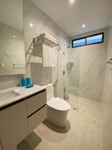 a white bathroom with a toilet and a shower at NOVAPARK HOTEL in Guayaquil