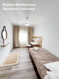 a bedroom with a large bed and a desk at El pisito mediterráneo in Melilla +12 photos