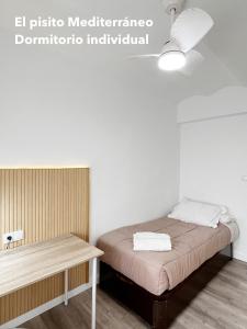 Habitación pequeña con cama y mesa en El pisito mediterráneo, en Melilla