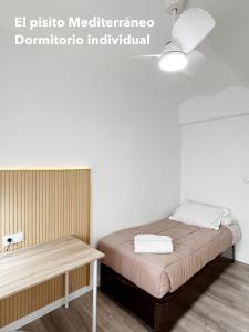 a small room with a bed and a table at El pisito mediterráneo in Melilla