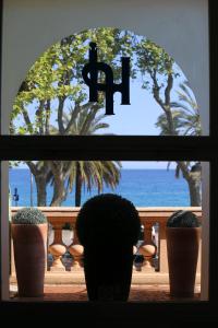 una ventana con macetas en un balcón con la palabra fija en Hotel Pavillon Imperial en Menton