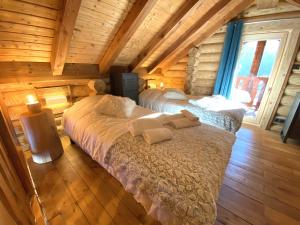 1 dormitorio con 2 camas en una cabaña de madera en L'OURSBLANC Chalet en rondins, en La Bresse