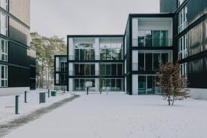 a building with snow on the ground in front of it at TheChipp - Designapartment mit Seeblick, Pool, Sauna & Kamin in Bad Saarow