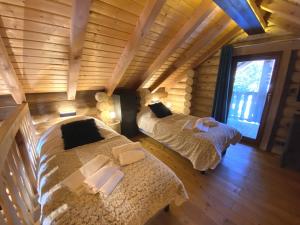 twee bedden in een kamer in een blokhut bij L'OURS NOIR Chalet en rondins in La Bresse