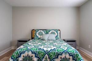 um quarto com uma cama verde e branca com 2 almofadas em Urban Oasis w/ King Bed – 3 BR Near Duke & DT em Durham