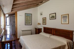 a bedroom with a bed and a table and a window at Casa Rural O Pozo in Borela