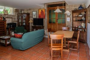 a living room with a table and chairs at Casa Rural O Pozo in Borela