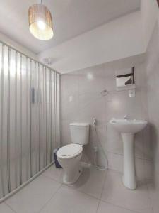 a bathroom with a toilet and a sink at Lady Sea Praia do Patacho in Pôrto de Pedras