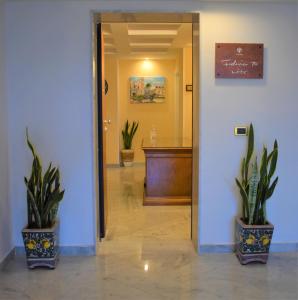 an office hallway with two potted plants and a podium at Federico 70 Arabic Style in Palermo