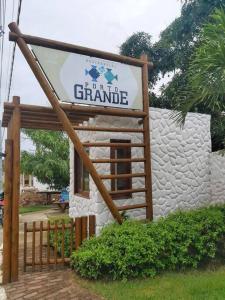 a sign in front of a stone building at Lady Sea Praia do Patacho in Pôrto de Pedras