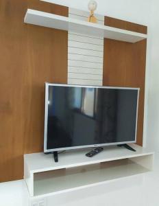 a flat screen tv sitting on a white shelf at Lady Sea Praia do Patacho in Pôrto de Pedras