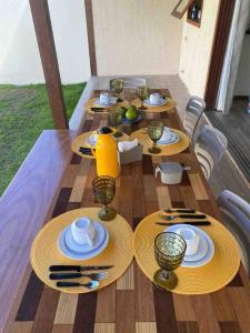 una mesa de madera con platos y utensilios. en Apartamento 110 Viva Barra, en Maraú