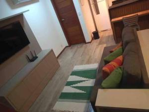 sala de estar con sofá y TV en Apartamento 110 Viva Barra, en Maraú