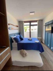 Un dormitorio con una cama azul y una ventana en Apartamento 110 Viva Barra, en Maraú