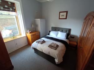 a bedroom with a large bed and a window at 4 bedroom / 2 bathroom house in desirable area. in Dundee