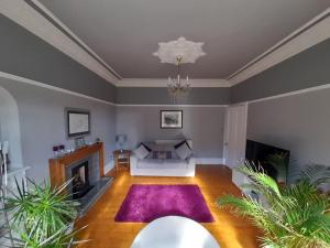 sala de estar con sofá y chimenea en 4 bedroom / 2 bathroom house in desirable area. en Dundee