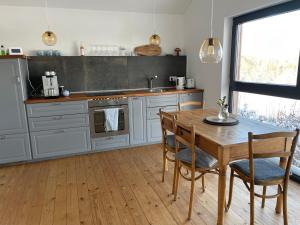 巴特明斯特艾弗爾的住宿－Eifelhaus UT Mutscheid，厨房铺有木地板,配有木桌。