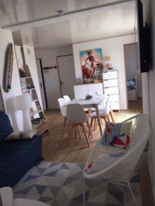 salon ze stołem i białymi krzesłami w obiekcie T3 FRONT DE MER LACANAU OCEAN - 22m2 TERRASSE -2 PISCINES -WIFI-PARKING w mieście Lacanau-Océan