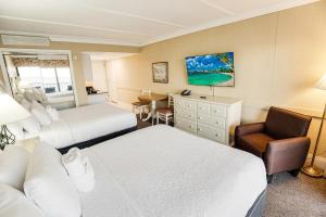 a hotel room with two beds and a chair at Beachy 5th Floor Oceanfront Room in Pawleys Island