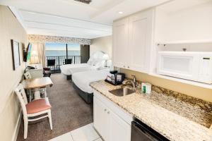 a hotel room with a bed and a kitchen at Beachy 5th Floor Oceanfront Room in Pawleys Island