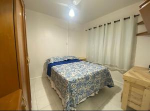 una camera con un letto e una coperta blu di Aconchegante e bem localizado a Salvador