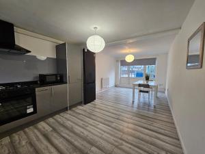 een woonkamer met een tafel en een keuken bij London Mile End Rooms in Londen