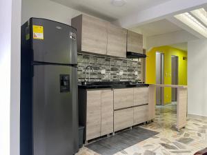uma cozinha com um frigorífico de aço inoxidável num quarto em Acojedora y comoda em Cali