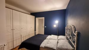 1 dormitorio con 1 cama con pared azul en Chihuahua_Apartaments, en Cracovia