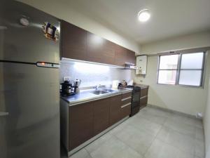 a kitchen with a sink and a refrigerator at Amplio departamento céntrico a 2 cuadras de la peatonal in Santa Fe