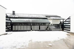 een gebouw met een hek en sneeuw op de grond bij Apartamento Alpino in Sierra Nevada