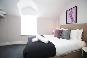 a bedroom with a large bed with white and purple pillows at Stay with Free Parking at Archer Road Penarth in Cardiff