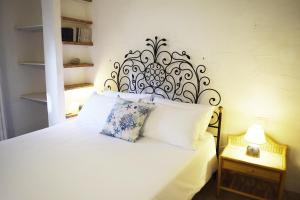 a bedroom with a white bed with a black headboard at Casa Agostina in Pula +82 photos