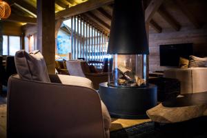 a fireplace in a living room with chairs and a couch at Au Coeur du Village in La Clusaz