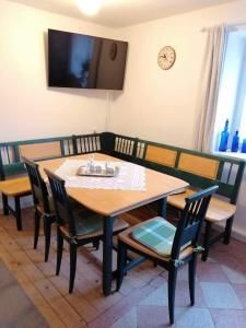 einen Esstisch mit Stühlen und einen TV an der Wand in der Unterkunft Ferienhaus Josefine in Bad Endorf
