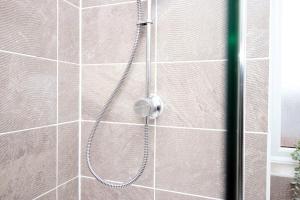 a shower with a hose in a bathroom at Church Road Cardiff FREE parking in Cardiff