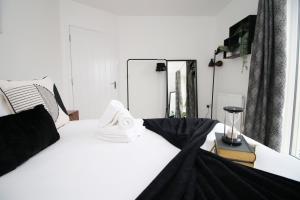 a bedroom with a white bed and a mirror at Church Road Cardiff FREE parking in Cardiff