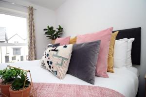 a bed with a bunch of pillows on it at Church Road Cardiff FREE parking in Cardiff