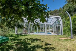 a glass greenhouse with a swimming pool in it at Casa Rural O Pozo in Borela