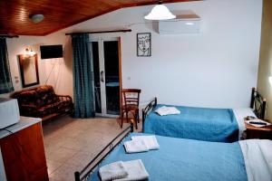 a bedroom with two beds and a living room at Hector's Studios in Alikanas
